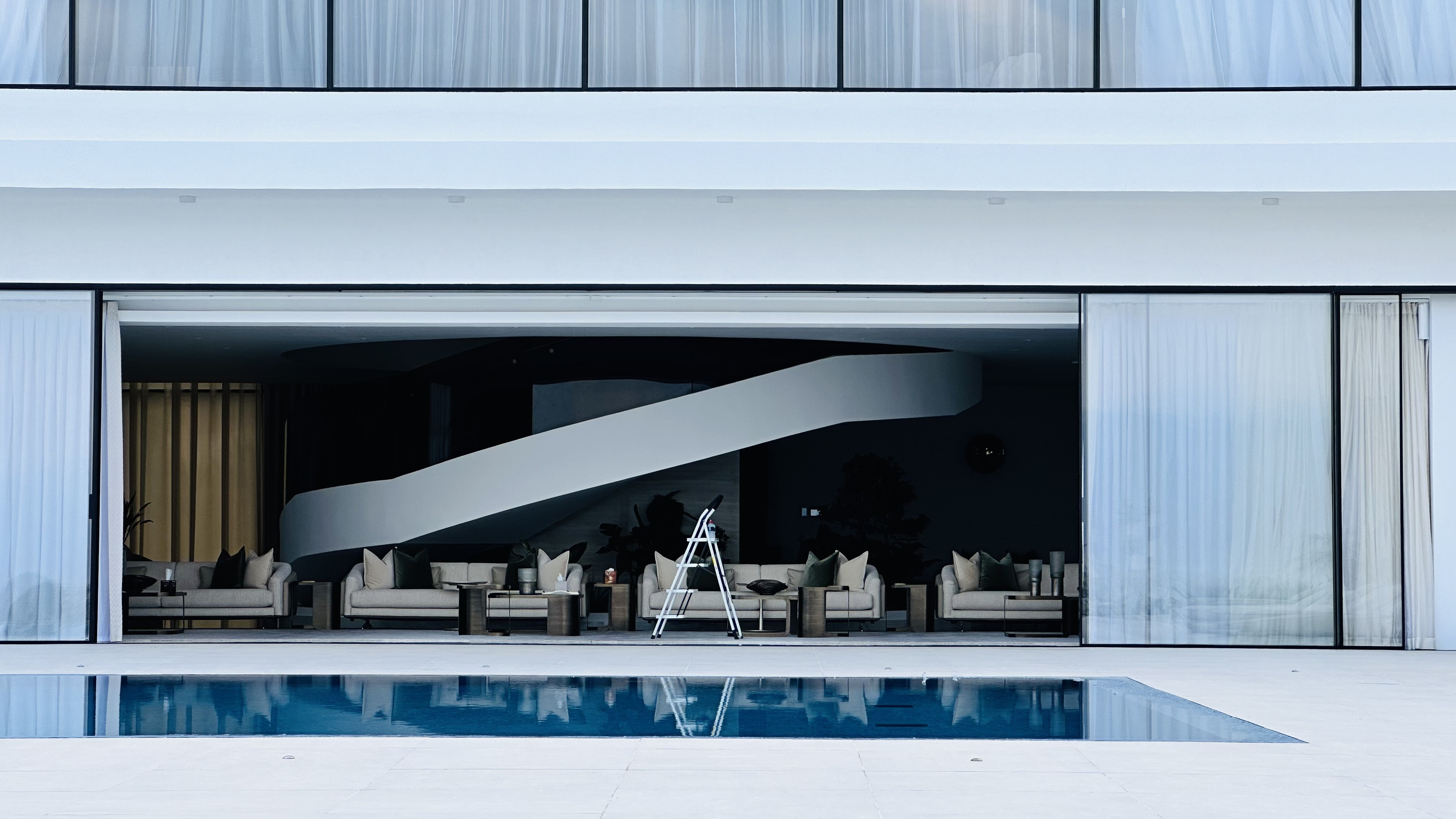 Indoor outdoor lounge opening to a pool