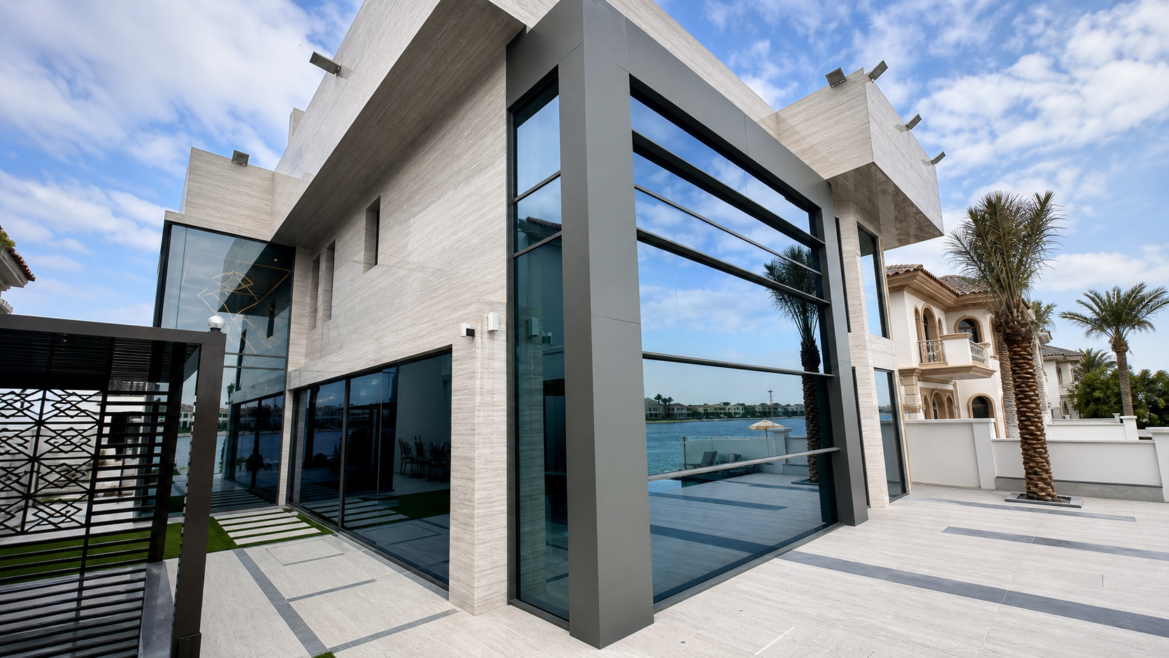 Contemporary villa exterior with large glazed facade and waterfront terrace views